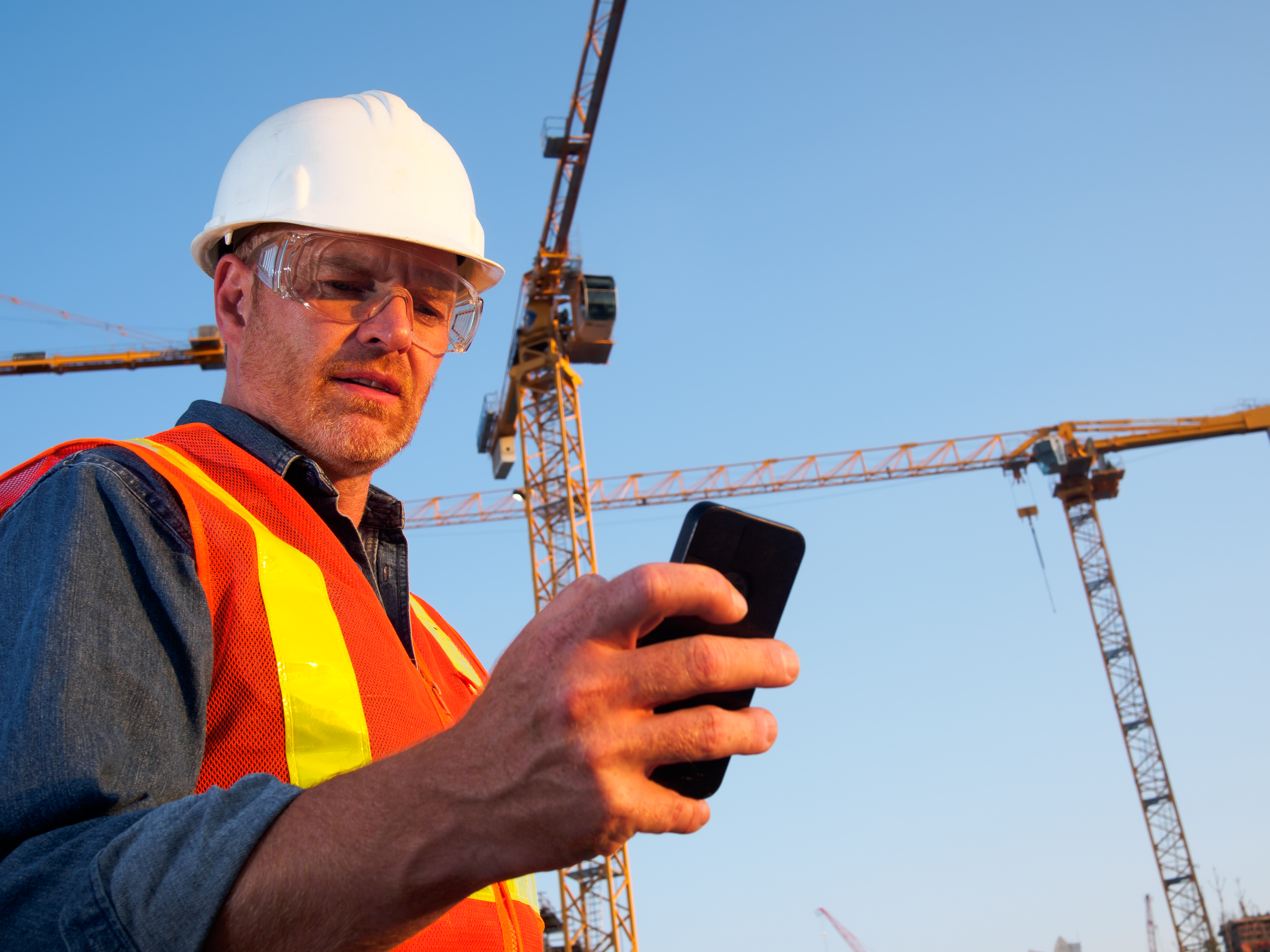 Superintendent checking phone on commercial jobsite