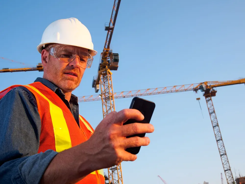 Superintendent checking phone on commercial jobsite